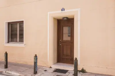 a brown door on the side of a building at Delightful 1BD Apartment in Plaka by UPSTREET in Athens