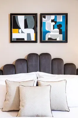 two framed art prints above a bed with pillows at Athenian Foss in Athens