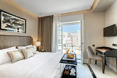 a bedroom with a bed and a desk and a window at Athenian Foss in Athens