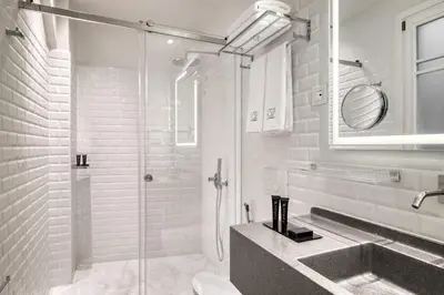 a white bathroom with a shower and a sink at Athenian Foss in Athens