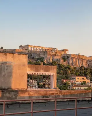 a building on a hill with a castle on top at Athenian Foss in Athens