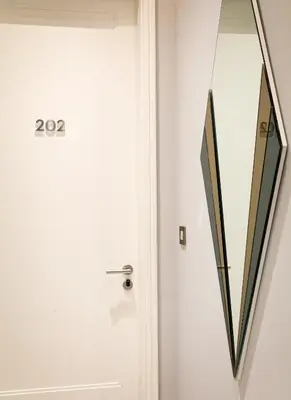 a white door with a mirror next to it at Athenian Foss in Athens