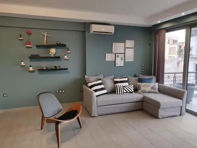 a living room with a couch and a chair at Elegant Bright Apartment with Acropolis view terrace in Athens