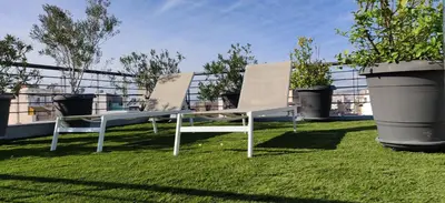 two chairs sitting on the grass on a roof at Elegant Bright Apartment with Acropolis view terrace in Athens
