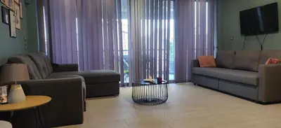 a living room with a couch and a table at Elegant Bright Apartment with Acropolis view terrace in Athens