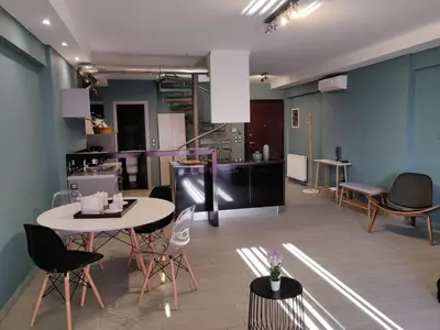 a room with a table and chairs and a kitchen at Elegant Bright Apartment with Acropolis view terrace in Athens