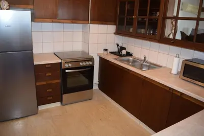 a kitchen with a stainless steel refrigerator and a sink at METROPOLITAN MACVIEW Διαμέρισμα in Piraeus
