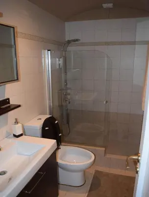 a bathroom with a shower and a toilet and a sink at METROPOLITAN MACVIEW Διαμέρισμα in Piraeus