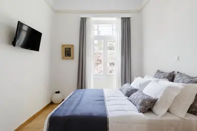 a bedroom with a bed with a tv on the wall at The Gem of Filopappou in Athens