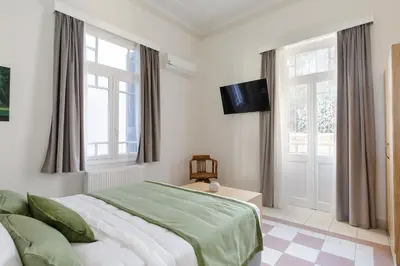 a bedroom with a bed and a tv on the wall at The Gem of Filopappou in Athens