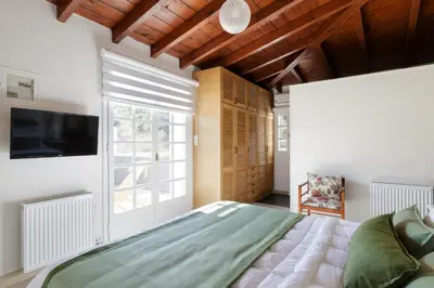 a bedroom with a large bed and a tv at The Gem of Filopappou in Athens