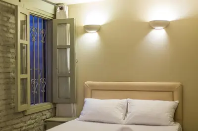 a bedroom with a bed with two lights on the wall at Plaka360 Apartments in Athens