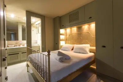 a bedroom with a bed and a bathroom with a sink at Plaka360 Apartments in Athens