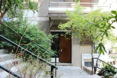 a building with a wooden door and some stairs at Athenian Hub Luxe Loft in Athens