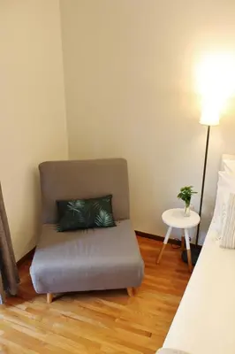 a bedroom with a chair with a pillow on a wooden floor at Athenian Hub Luxe Loft in Athens