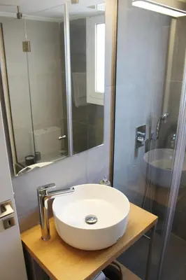 a bathroom with a white sink and a shower at Athenian Hub Luxe Loft in Athens