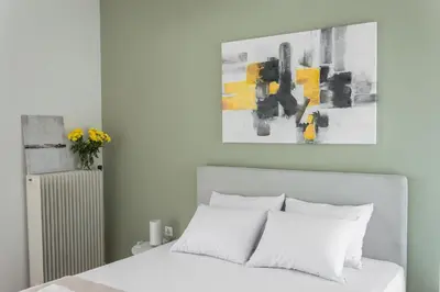 a bedroom with a white bed and a painting at Elegance in Athens in Athens