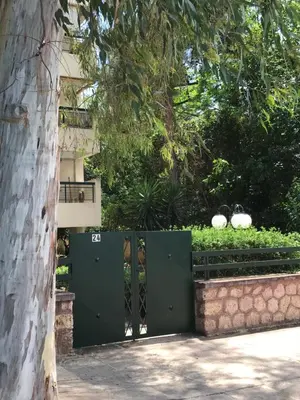 a green gate in front of a building at aris sweet home 2 in Athens
