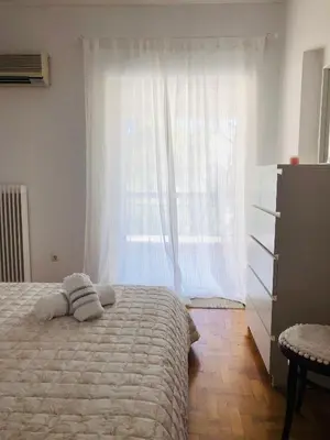 a bedroom with a bed and a large window at aris sweet home 2 in Athens