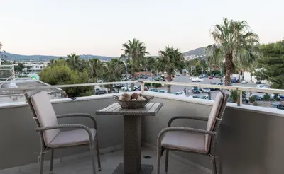a table and chairs on a balcony with a view of a city at Alex's place in Vari