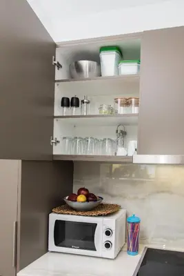 a microwave in a kitchen with a bowl of fruit at Alex's place in Vari