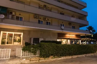 a large building with bushes in front of it at Alex's place in Vari