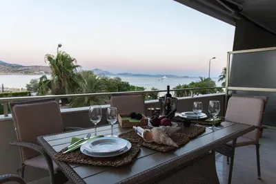 a table with food and wine glasses on a balcony at Alex's place in Vari