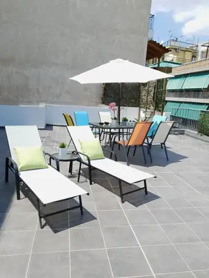 a group of chairs and tables with an umbrella at Spacious 110m2 2bedrooms 2bathrooms Center Athens in Athens