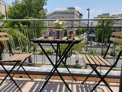 a table on a balcony with two chairs and flowers at Spacious 110m2 2bedrooms 2bathrooms Center Athens in Athens