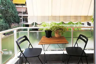 a table on a balcony with two chairs and a table at Tiny Studio Suite in Athens