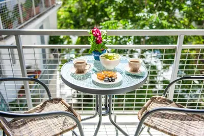 a table with two chairs and a plate of food at AthensHub - Across Metro Station in Athens