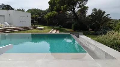 a swimming pool with blue water in a yard at Summer Villa in Porto Rafti in Porto Rafti