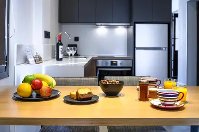 a kitchen with a wooden table with fruit on it at Hidesign Athens Acropolis Panorama Suite in Athens