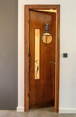 a wooden door with a mirror in a room at Hidesign Athens Acropolis Panorama Suite in Athens