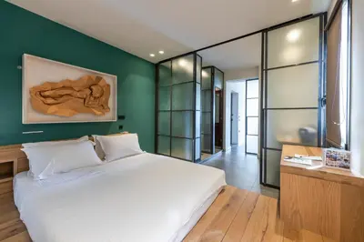 a bedroom with a white bed and a green wall at Hidesign Athens Acropolis Panorama Suite in Athens