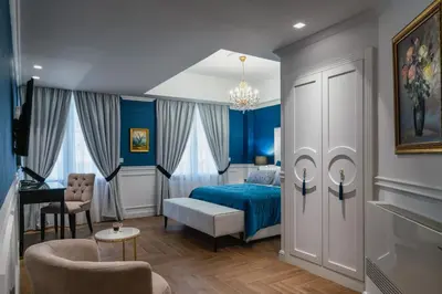 a bedroom with blue walls and a bed and a desk at Evripidou Suites in Athens