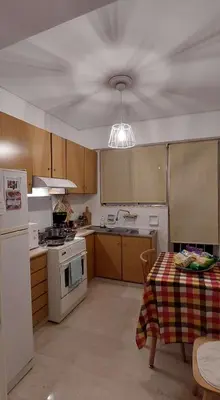 a kitchen with a table and a ceiling fan at Alianthos Beach Apartment in Vari