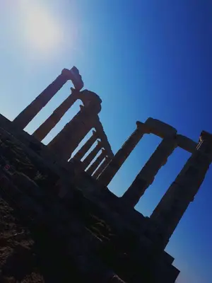 a building with the sun in the background at Alianthos Beach Apartment in Vari