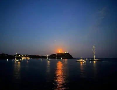 a group of boats in the water at night at Alianthos Beach Apartment in Vari