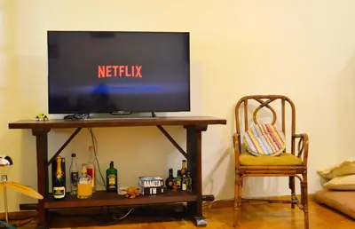 a television on a table in a room with a chair at Acropolis in Athens