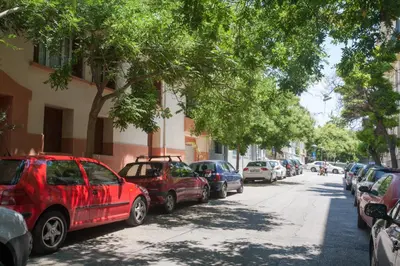 a row of cars parked on the side of a street at Acropolis in Athens