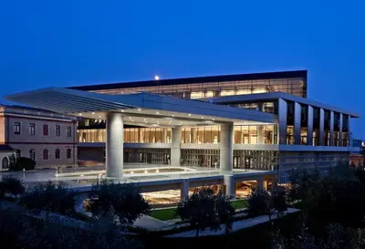 a large building with lights on in front of it at Acropolis in Athens