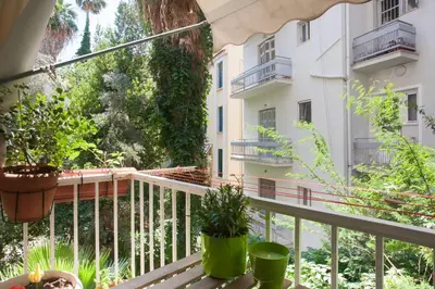 a balcony with a table and potted plants on it at Acropolis in Athens
