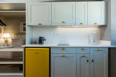 a kitchen with blue and yellow cabinets and a bed at Downtown Athens Lofts by Raise in Athens