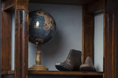 a wooden shelf with a globe and boots on it at Downtown Athens Lofts by Raise in Athens