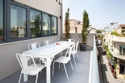 a white table and chairs on the balcony of a building at Downtown Athens Lofts by Raise in Athens