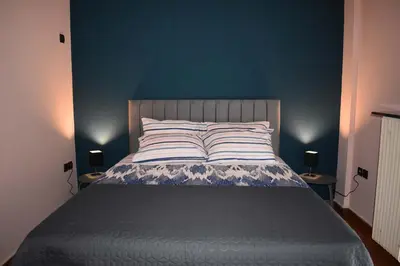 a bedroom with a bed with a blue wall at Katzen Room by the Metro in Athens