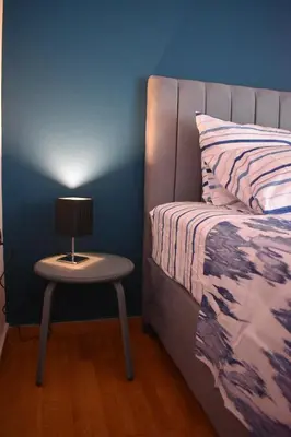 a bed and a table with a lamp on it at Katzen Room by the Metro in Athens