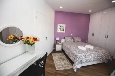 a bedroom with a bed and a mirror and flowers at Gaspar Apartment - 4th floor - Renovated 2019 in Athens