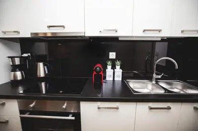 a black kitchen with a sink and a counter at Ziva Apartment - 4th floor - Renovated 2019 in Athens